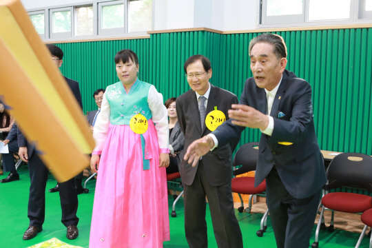 25일 서울시 강동구에 있는 지적장애인 복지시설 우성원에서 열린 창호 교체 준공 기념식에서 (오른쪽부터)김원제 서울시장애인복지시설협회 회장과 박찬구 금호석유화학그룹 회장 등이 한가위 맞이 윷놀이를 하고 있다. <금호석화 제공>